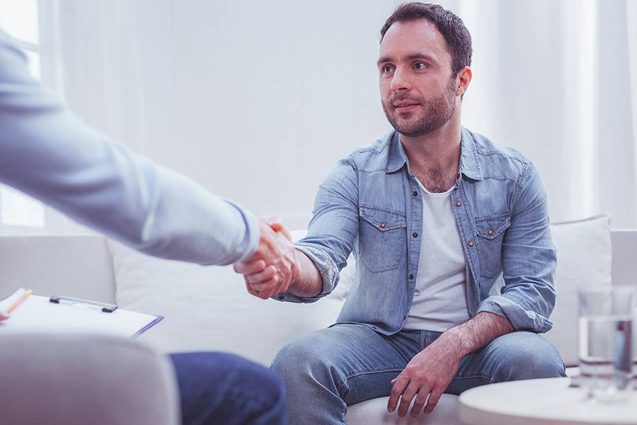 Satisfied man expressing gratitude to his personal psychiatrist Satisfied man expressing gratitude to his personal psychiatrist